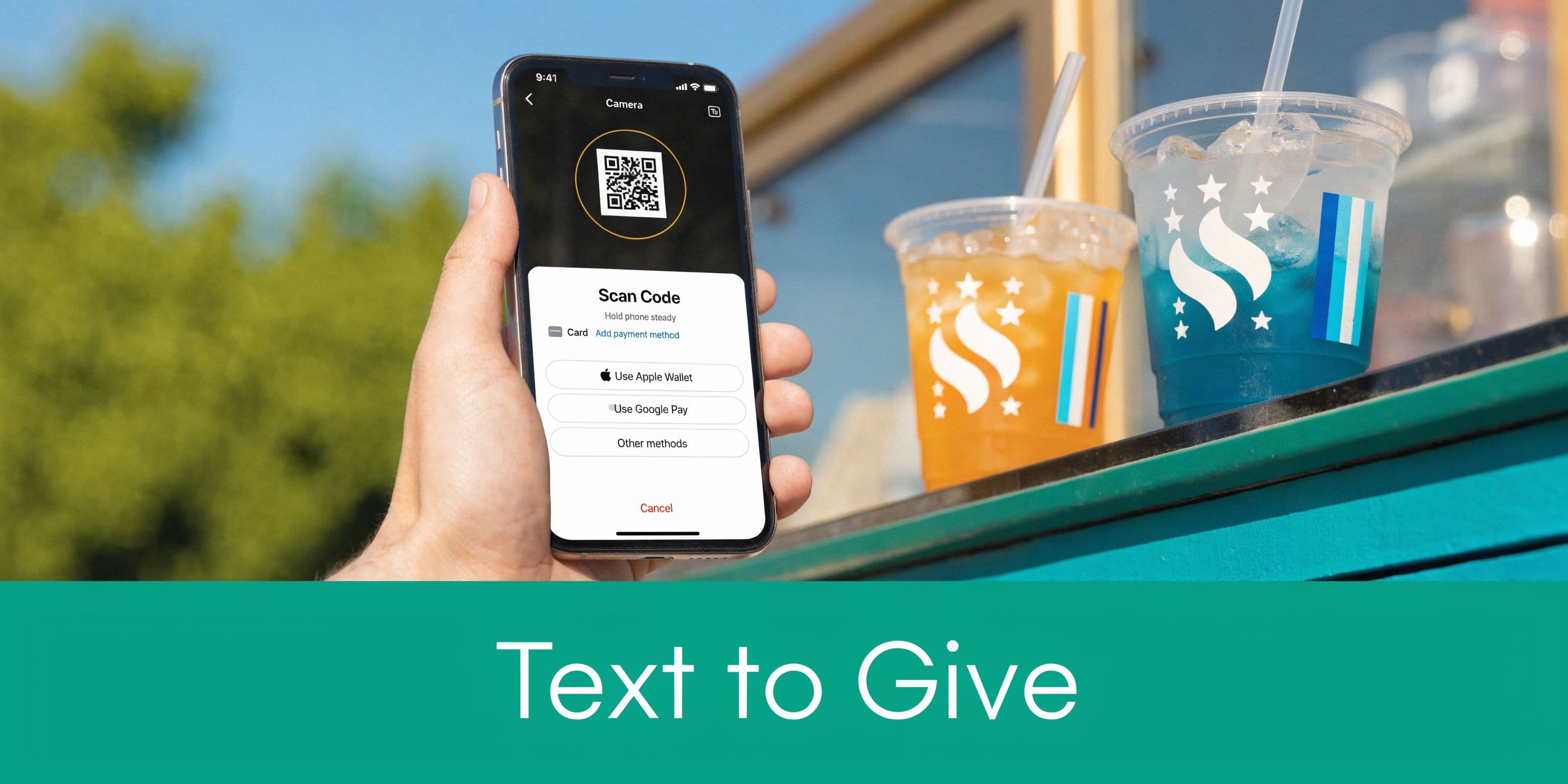 A hand holding a smartphone to scan a QR code at a concession stand for mobile payments.